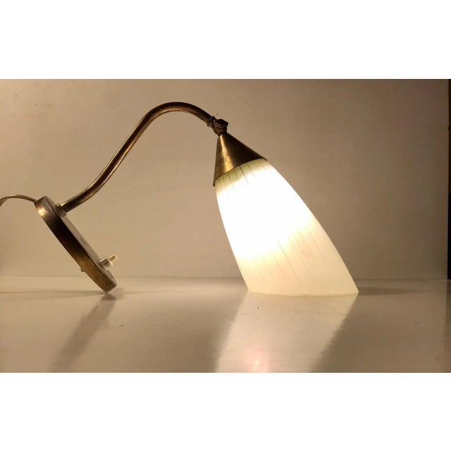 Early 1950s wall light made in Scandinavia in a style reminiscent of Stilnovo and the french modernist movement. Its...