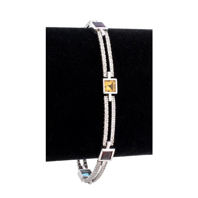 14K White Gold Multi-Color Gemstone and Diamond Set Bracelet. Adorned with bezel set Amethyst (two), Blue Topaz (two),...