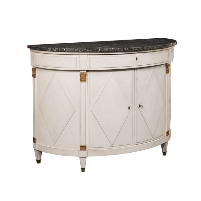 A French Neoclassical painted demilune cabinet, with its original marble top, from the mid 19th century. This antique...