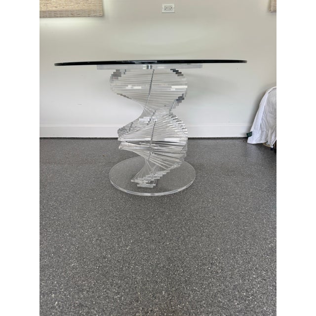 Striking vintage 1980s sculptural Lucite dining table featuring a dramatic helical “twist” base constructed from...