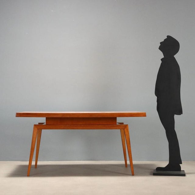 Italian-made 1960s table crafted from oak wood, featuring a minimalist design that reflects the period's style. The top is...