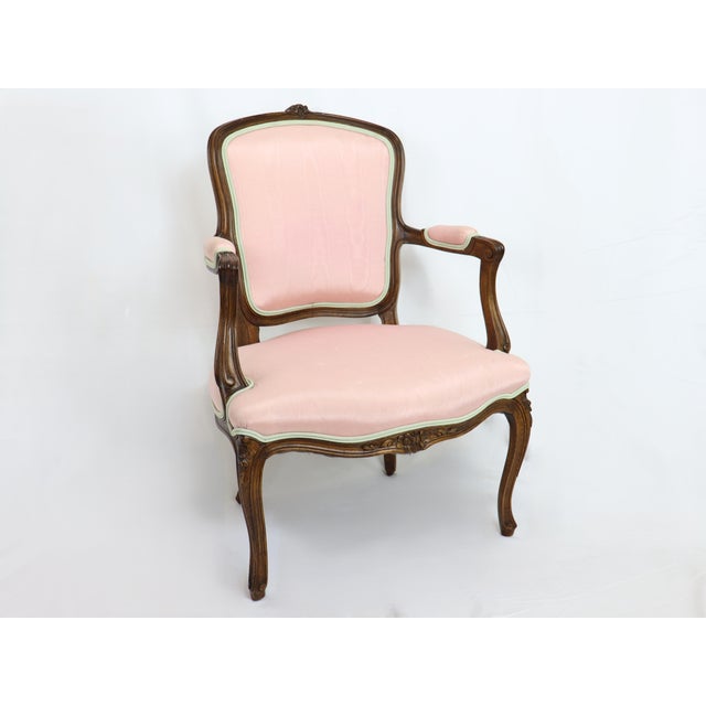 Antique French Provincial Louis XV style open arm Bergere with pink silk fabric. Solid walnut with hand carved floral...