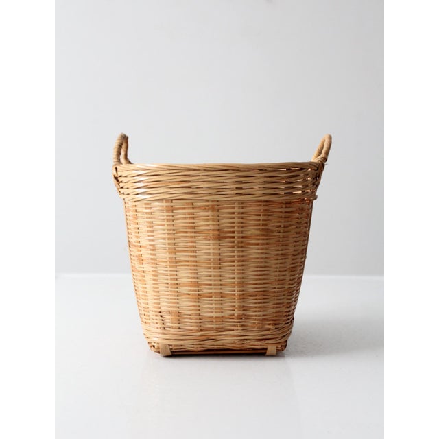 This vintage handwoven basket presents a sculptural form with an open, airy weave and a soft natural wicker tone. The...