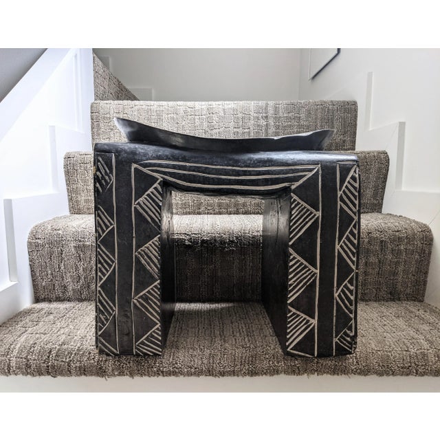 A striking, hand carved, African pedestal stool crafted from a single piece of wood. This vintage piece reflects the...