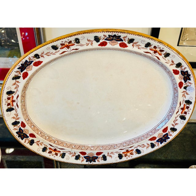 A striking pair of generously sized antique English serving platters decorated in a richly colored Imari-inspired floral...