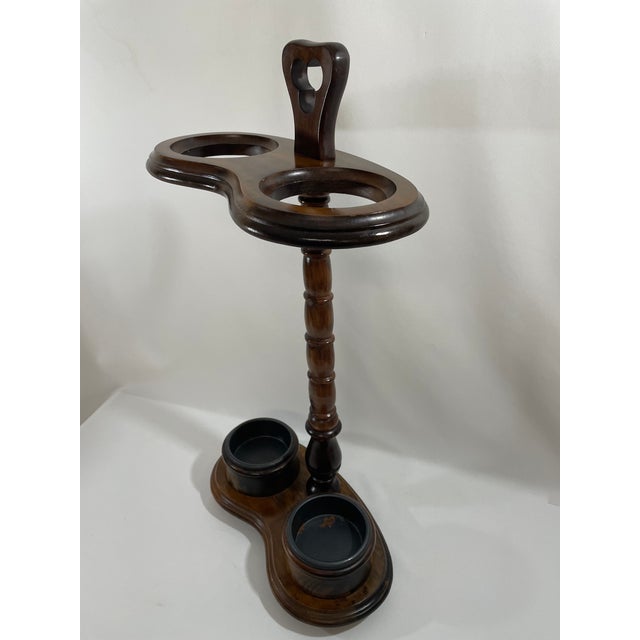 A stunning vintage Victorian Style Umbrella or Stick Stand with metal drip pans, circa 1980s. This solid walnut stand is...