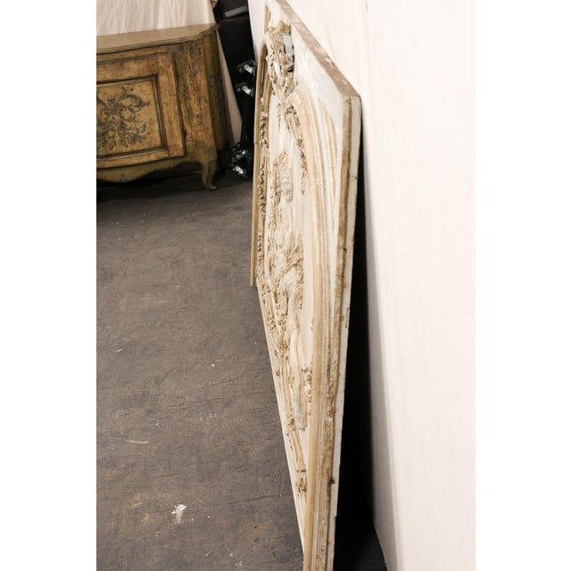 A large-sized French relief-carved and painted decorative wall panel from the 19th century. This antique plaque from...