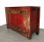 This red cabinet in a warm antique red has two doors with carved gold and black borders which open to a large cabinet with...
