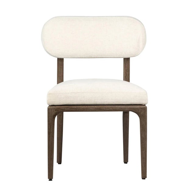 Midcentury modern inspired dining chair with brown mindi wood frame and off-white cotton blend upholstered seat and back....
