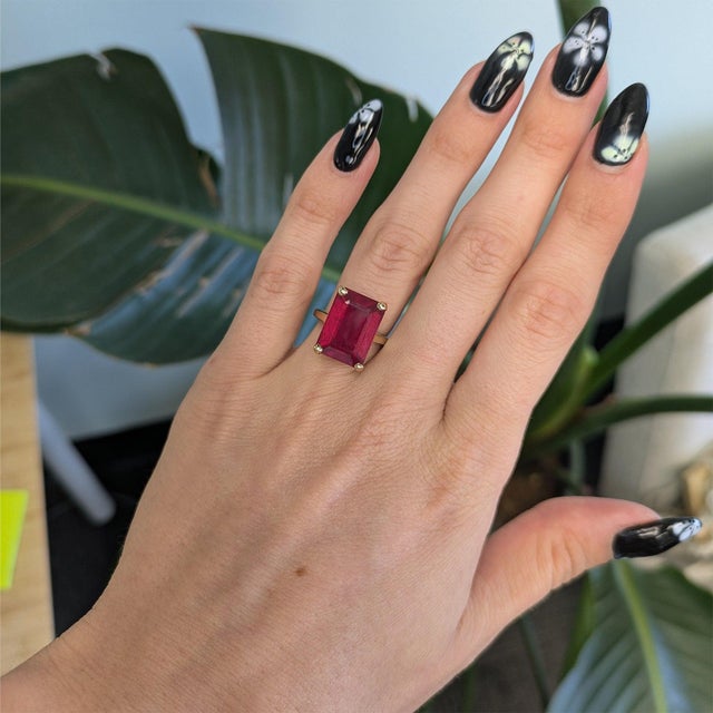 A dramatic Estate 13.90-carat Madagascar ruby takes center stage as a bold emerald-cut solitaire in solid 10K yellow gold....