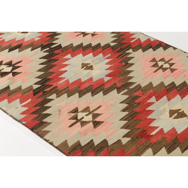 This is a vintage Turkish Oushak rug from the Mid 20th Century. The piece was hand-knotted.