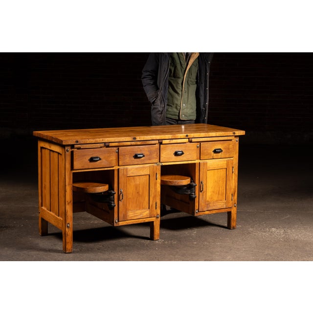 Substantial walnut workbench constructed with a thick plank top, paneled case sides, and an integrated system of drawers,...