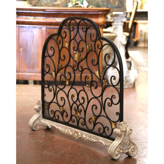 Sculptural ironwork and richly carved details give this vintage French fireplace screen an elegant decorative presence....