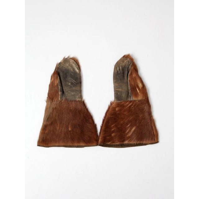 A pair of antique fur mittens circa early 20th century. The brown fur gloves feature leather palms. The interior is lined...