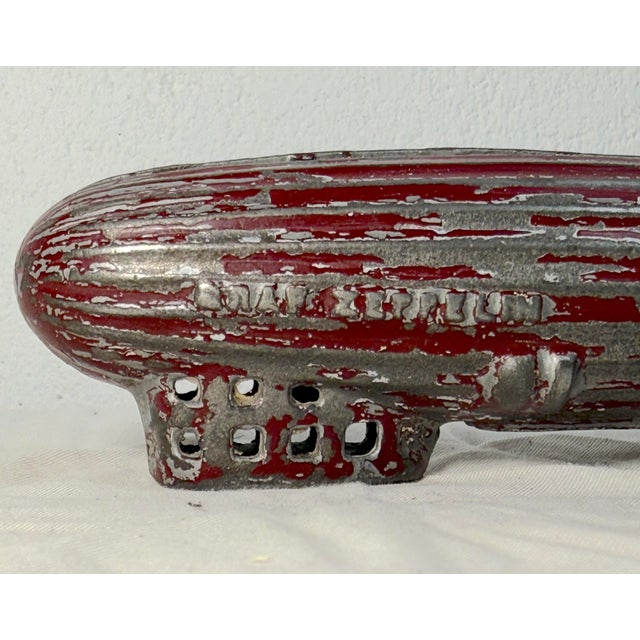 The antique 1920's original AC Williams red Graf Zeppelin cast iron still bank is a rare and unique collectible piece...