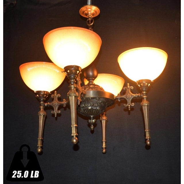 A substantial and highly decorative mid-century four-light chandelier combining sculptural bronze metalwork with four...