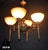 A substantial and highly decorative mid-century four-light chandelier combining sculptural bronze metalwork with four...