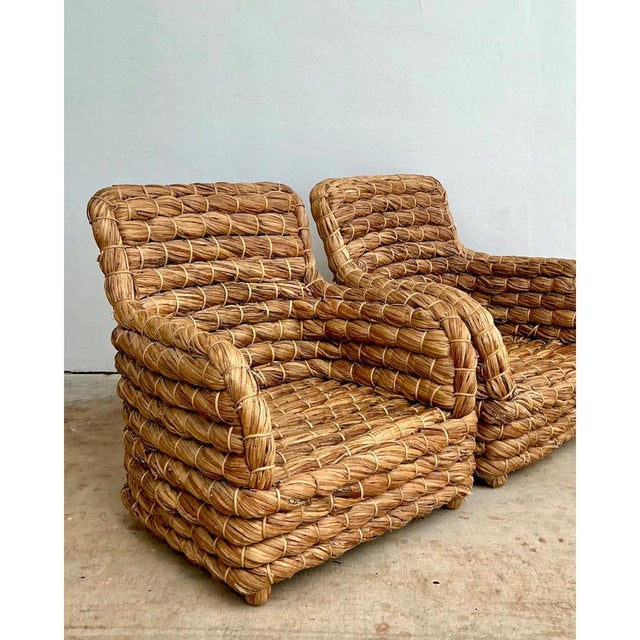 This pair of vintage lounge chairs is entirely constructed from thickly twisted rush, wound and bound into substantial...