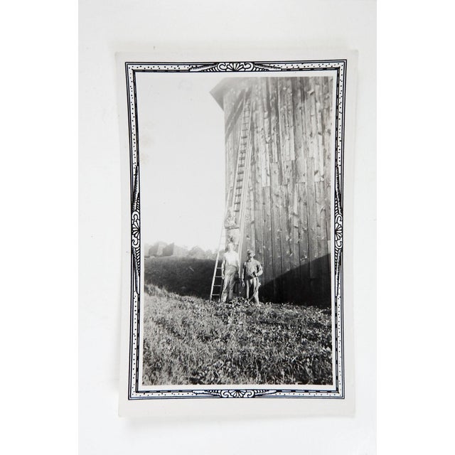 Early 20th century snapshot photograph of farm workers next to an extremely tall barn and extremely tall ladder. Unframed,...