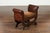 A petite English leather-bound stool from the early 20th century, with out-scrolling arms and nailheads. Created in...