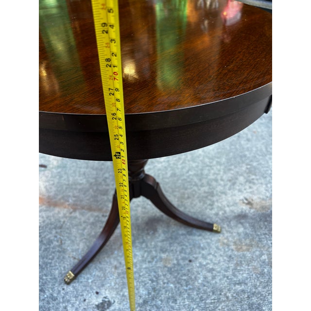 Up for consideration is a beautiful vintage round mcm wooden side table with brass claw feet. This would look lovely in...