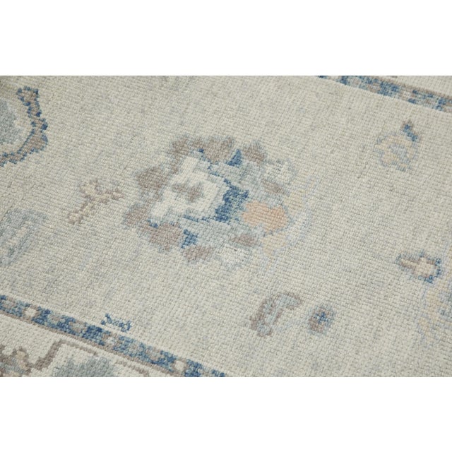 This modern Turkish Oushak rug is a stunning piece of art that has been handwoven using traditional techniques by skilled...