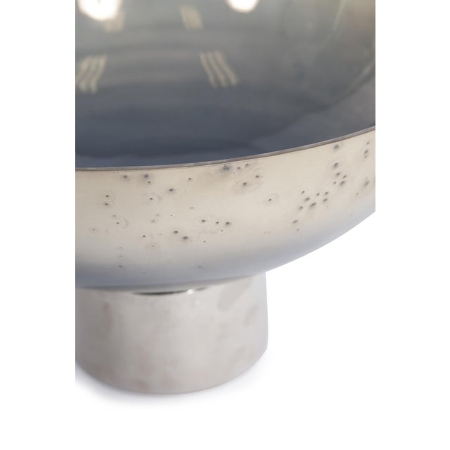 This lovely bowl features a glass body with an ombre coloring from a light sand color graduating to a silvery blue. It...