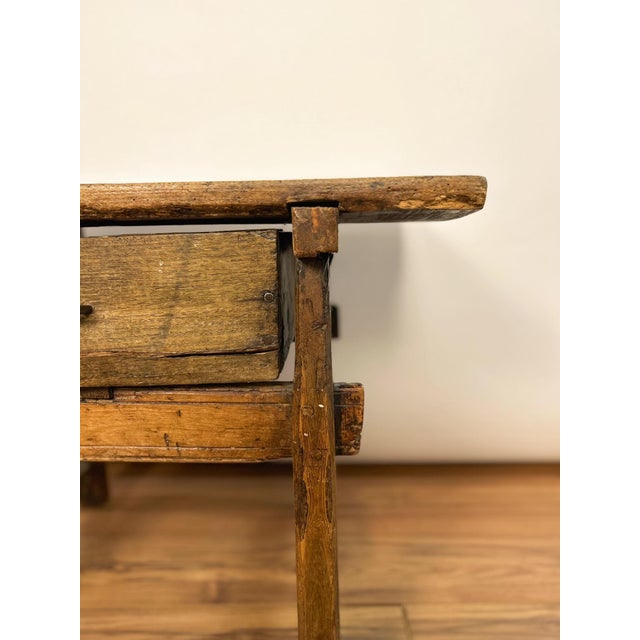 18th century Spanish side table handcrafted from solid wood. This small, rustic piece features a thick plank top, simple...