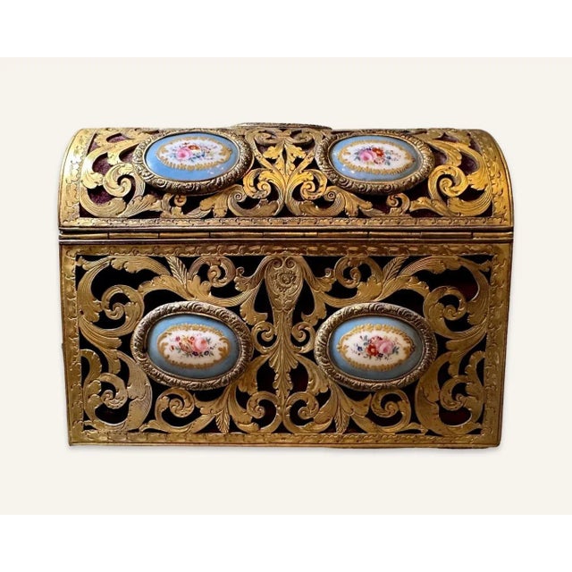 Sèvres porcelain lozenges are couched in elaborate pierced gilt brass scrollwork lined with red velvet. The interior is...
