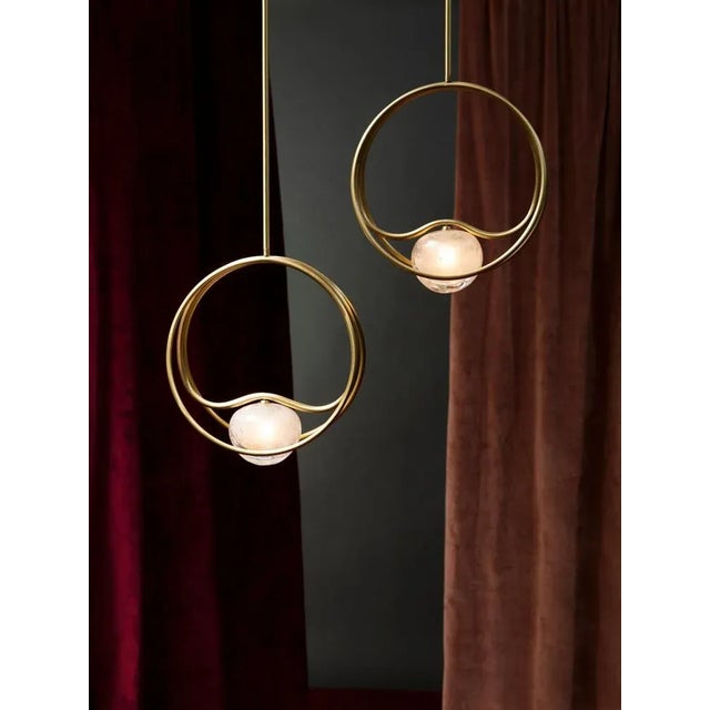 Pair of brass "Pulsar Singolo" chandelier. Dimensions: 36 x 10 x 36cm. Materials: Brass, crystal. Brass rings with a satin...