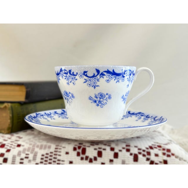 This vintage fine bone china footed teacup and saucer set was crafted by Shelley in Staffordshire, England. It features...