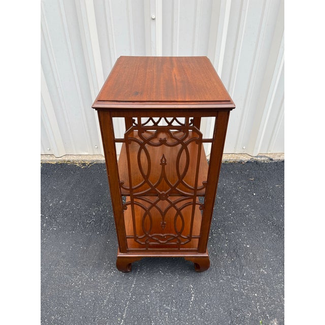 A mid 20th century walnut Etagere with clear chinoiserie stylized influences. Two shelves below a flat Etagere top,...