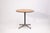 A Herman Miller round side table with wood top and metal base. The table features a circular wood surface with a...