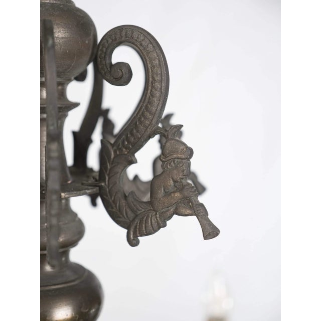 Bronze chandelier with mascarons and whistles. Very high-quality design from the 19th century. The arms are decorated with...