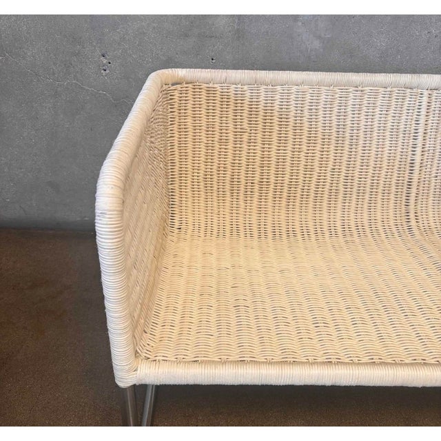 Sculptural two-seat settee featuring a tightly woven ivory rattan shell over a sleek tubular chrome cantilever frame....