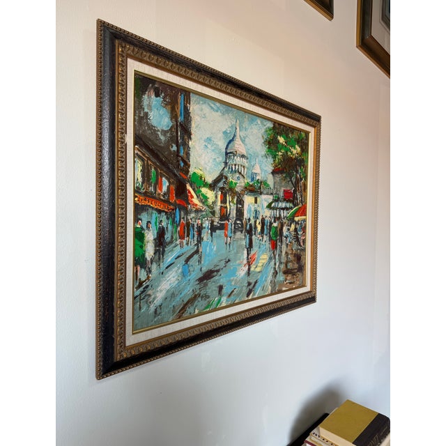 Charming mid-century Parisian street scene oil painting depicting a lively European cityscape, likely inspired by...