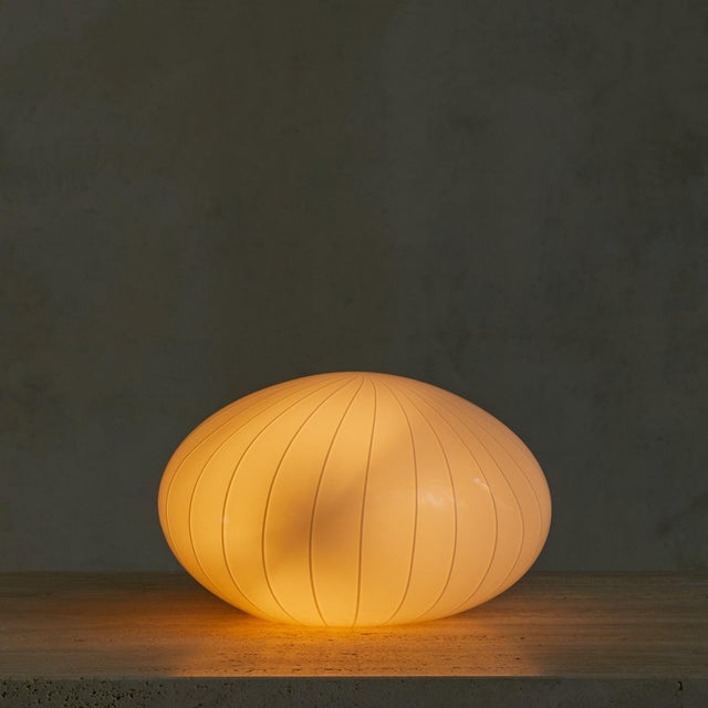 A 1970s Italian table lamp in Murano glass, the dome shade hand-blown in opaque white with delicate vertical striations...
