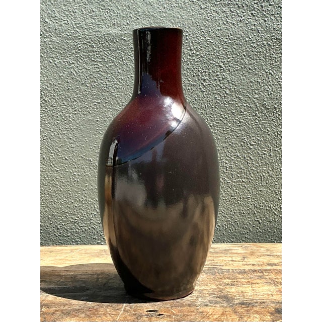 This striking vintage studio pottery vase exhibits a sophisticated balance of sleek form and rich, moody color. The hand-...