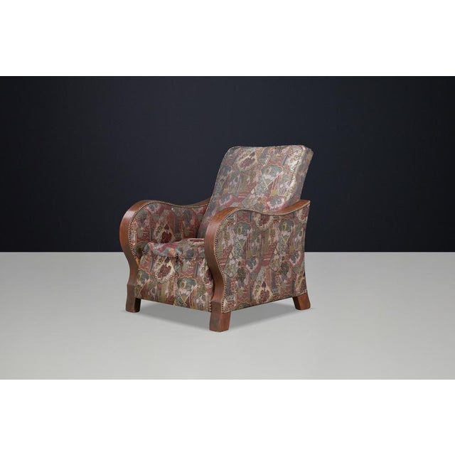 A striking Dutch Art Deco lounge chair dating from the 1930s, distinguished by its elegant sculptural armrests executed in...