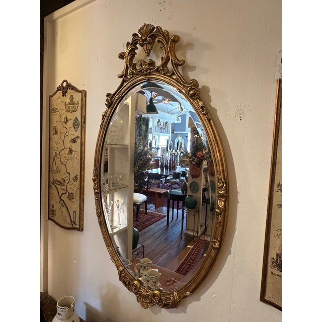 Lovely oval giltwood French style mirror having beveled mirror.