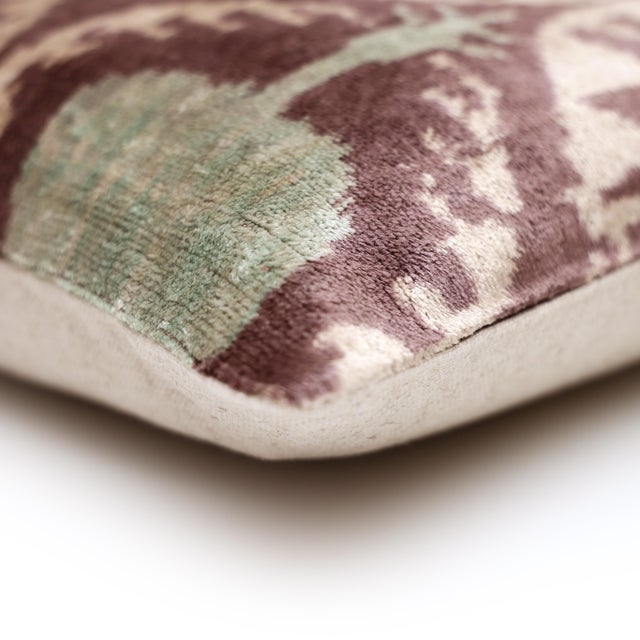 "A softer, more nuanced expression of traditional Ikat, this handcrafted lumbar pillow introduces a refined medallion...