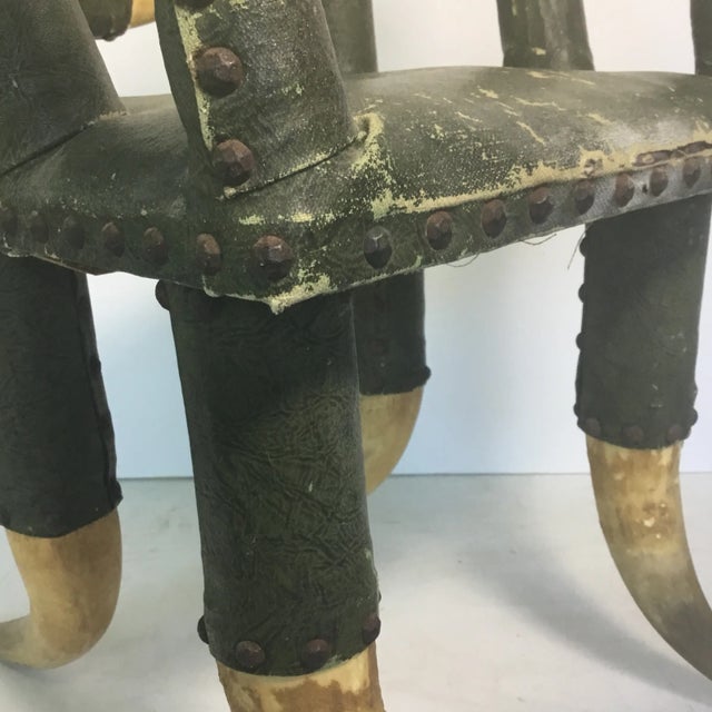 A wonderful early 20th century child 11 horn chair with green coated fabric faux leather upholstery and round tac detail....