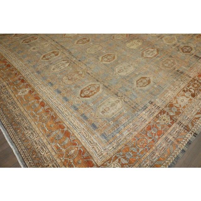 1900s Persian Bibikabad Antique Oversized Rug in grays, blues, caramel, and rust tones