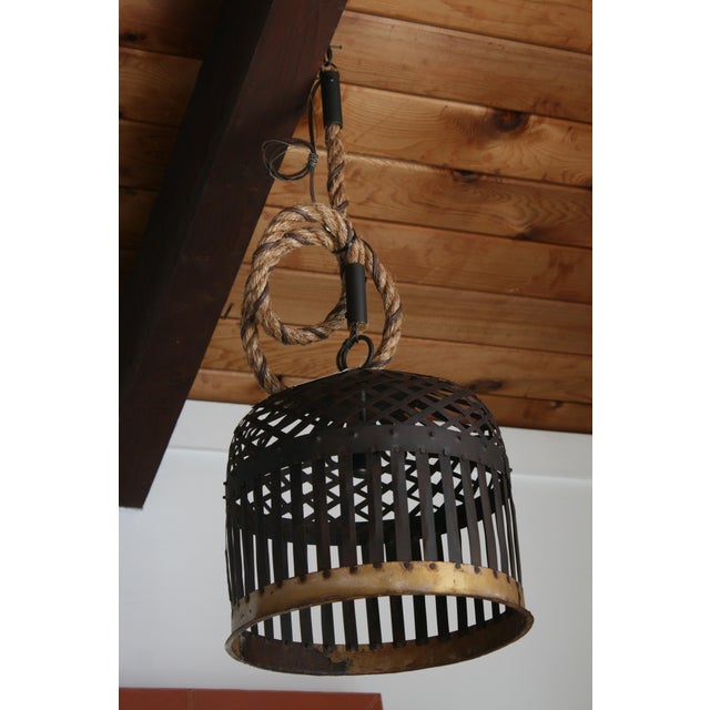 This stunning pendant light by Cisco combines rustic charm with modern ingenuity. The light features an iron, black cage...