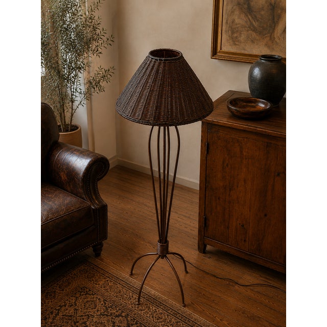 Elegant floor lamp featuring a sculptural wrought iron frame paired with a beautifully handwoven bamboo shade. Dating from...