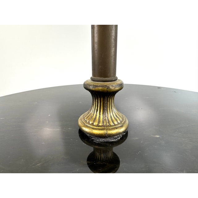 A thoughtfully designed early to mid 20th century floor lamp featuring a turned wood base, aged brass stem, and an...