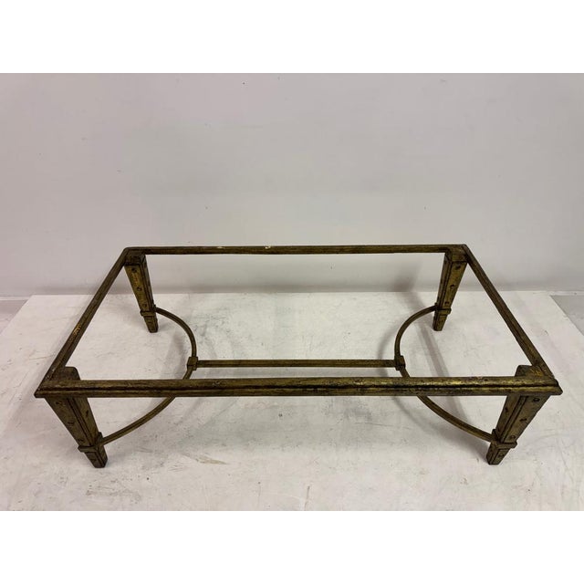 A French mid-century coffee table combining a sculptural gilded wrought iron base with a substantial stone top. The...