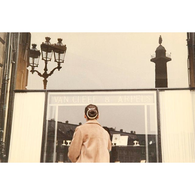 Paris Window Shopping A woman at the entrance to Van Cleef & Arpels jewllers with the Colonne Vendôme reflected in the...
