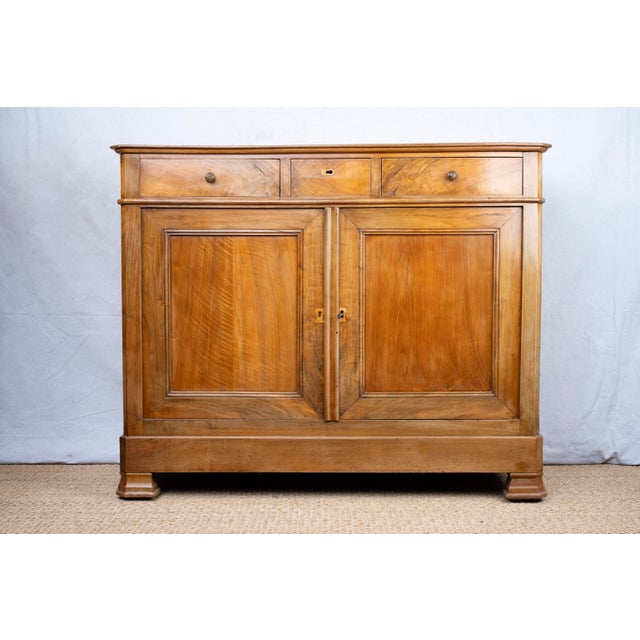 A sideboard/buffet in walnut, c. 1880, Italian. Features three drawers with dovetail joints. Two drawers have matching...