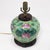 This vintage Chinese porcelain lamp features colorful hand-painted lotus flowers on one side and a lively still life of...